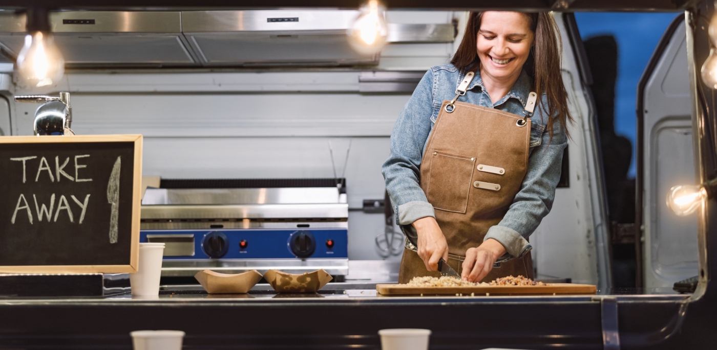 Woman with apron preparing takeaway for her food truck