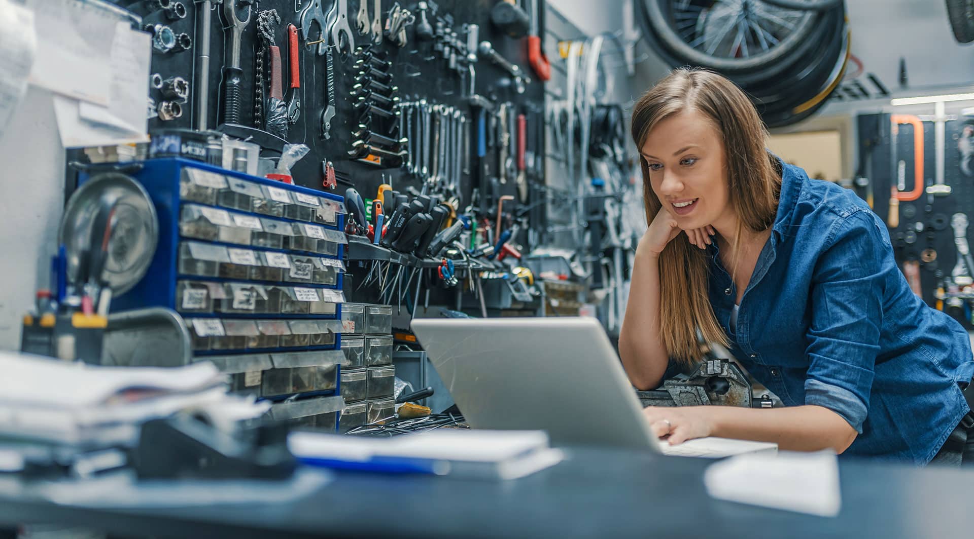 Woman in tool house looking at laptop