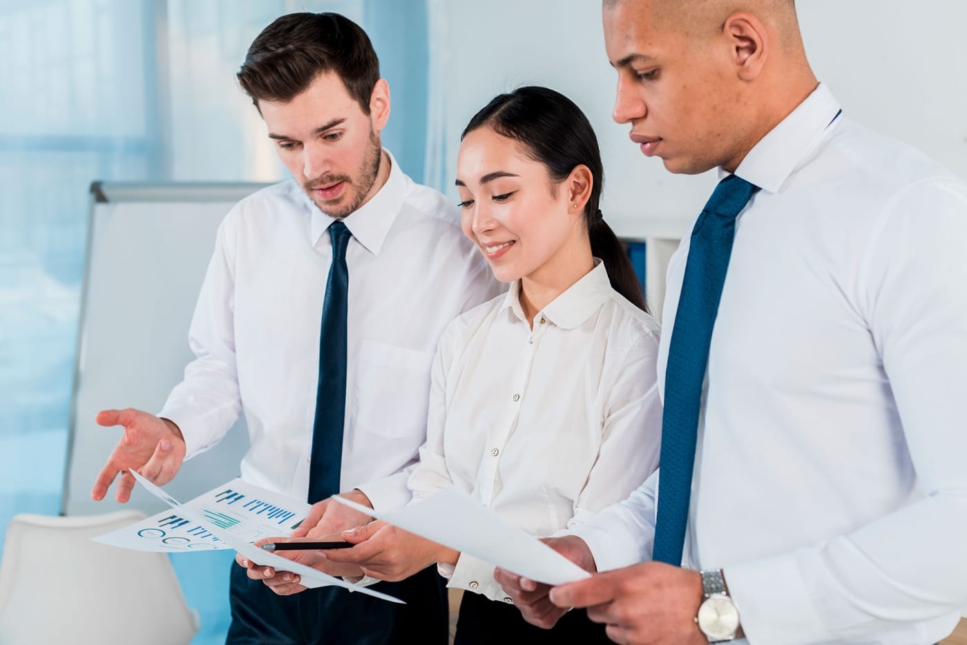 3 people in button up shirts looking at data visualisations