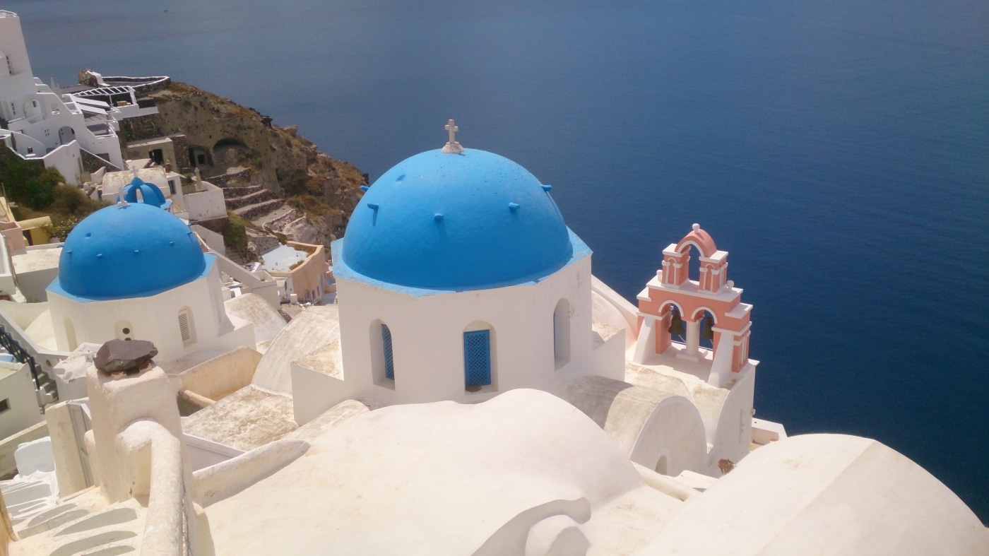 classic greek travel scene with white buildings a blue roof tops